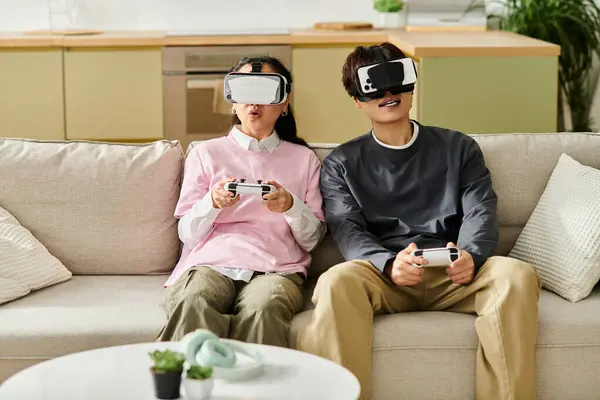 Un jeune couple plongé dans le jeu de réalité virtuelle, s'amusant dans leur cadre de vie moderne. — Photo de stock