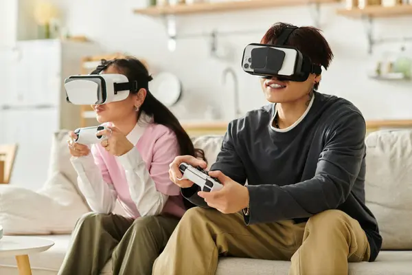 This young couple is immersed in a virtual reality gaming experience at home, smiling and focused. — Stock Photo