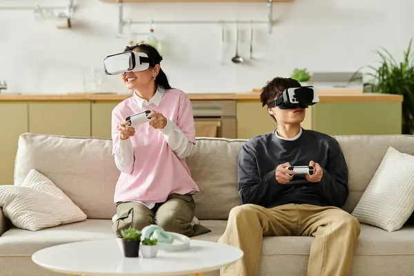 A young couple plays virtual reality games together at home, fully immersed in their adventure. — Stock Photo