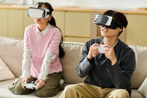 A young asian couple enjoy a fun gaming session at home while using virtual reality headsets. — Stock Photo