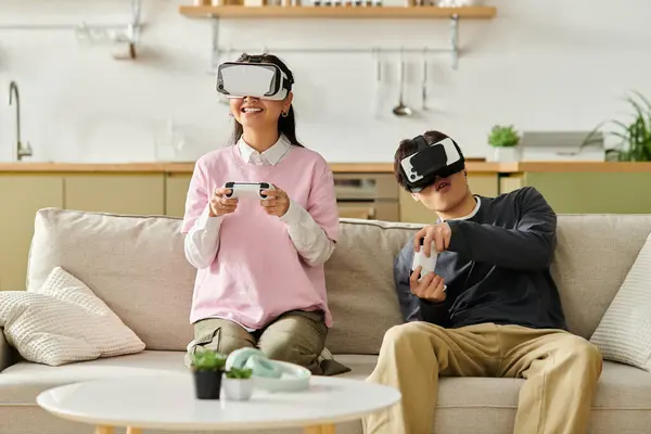 A couple enjoys virtual reality gaming together on the sofa, relaxing and having fun. — Stock Photo