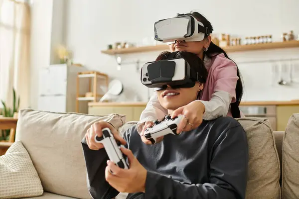 A young couple enjoys virtual reality gaming together, immersed in their cozy living room. — Stock Photo