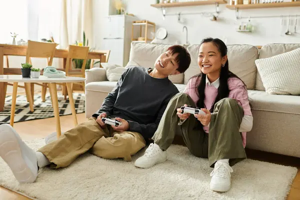 Ein glückliches Paar spielt zu Hause Videospiele auf dem Fußboden und genießt einen gemütlichen Moment zusammen. — Stockfoto