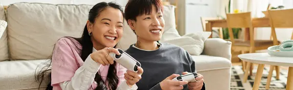 Ein glückliches junges Paar spielt zusammen Videospiele in ihrem einladenden Zuhause, teilt Lächeln und Lachen, Banner — Stockfoto