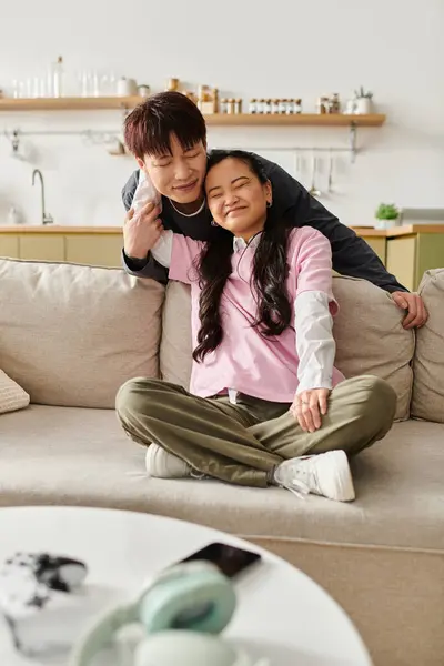 Young couple shares a joyful and intimate moment on the couch at home, radiating happiness. — Stock Photo