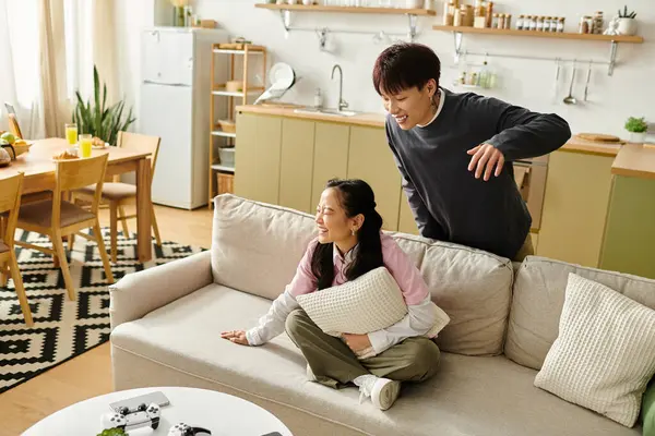 A young couple enjoys laughter together in their stylish living room, embracing happiness. — Stock Photo