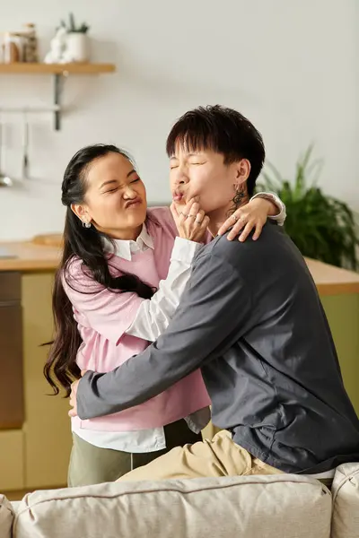 A young asian couple playfully enjoying each other's company on a cozy couch at home. — Stock Photo