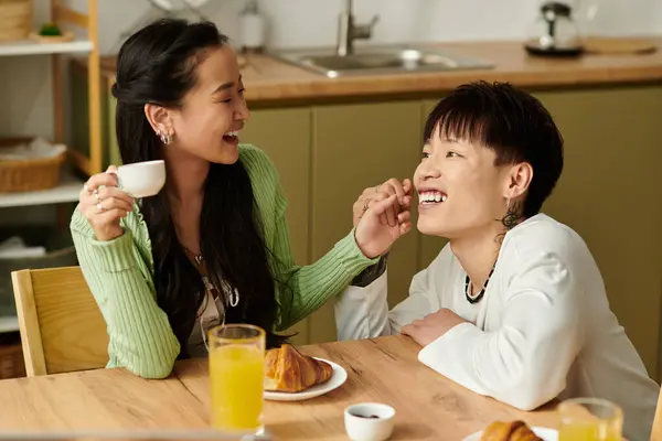 A young couple shares laughter and smiles over breakfast in their cozy kitchen. — Stock Photo
