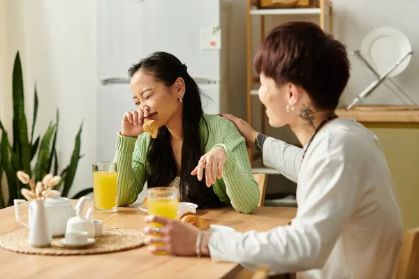 Young couple enjoys a light breakfast together, sharing smiles and playful moments at home. — Stock Photo
