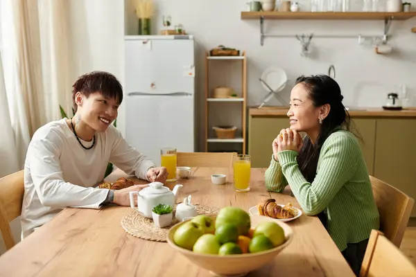 A young couple enjoys breakfast together, sharing smiles and delicious food at their home. — Stock Photo