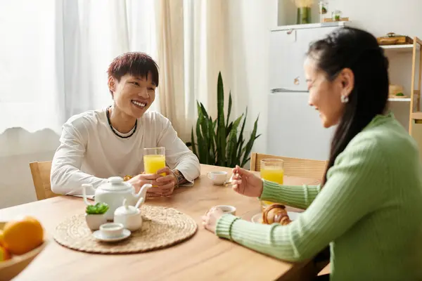 A young couple enjoys breakfast together at home, smiling and sharing delightful conversation. — Stock Photo