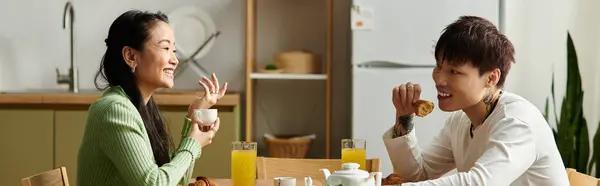 Joyful couple shares laughter and tea while enjoying breakfast in their warm kitchen, banner — Stock Photo