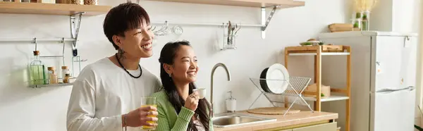 A young smiling Asian couple savors breakfast in their bright, inviting kitchen, banner — Stock Photo
