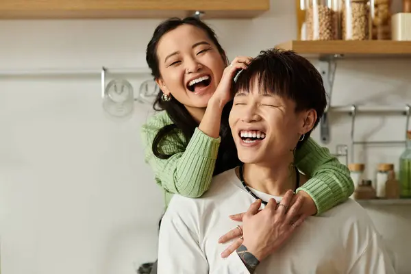 Laughter fills the cozy kitchen as the young couple shares a light-hearted breakfast moment. — Stock Photo