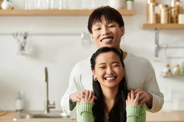 A vibrant young couple smiles while sharing breakfast at their cozy home kitchen. — Stock Photo