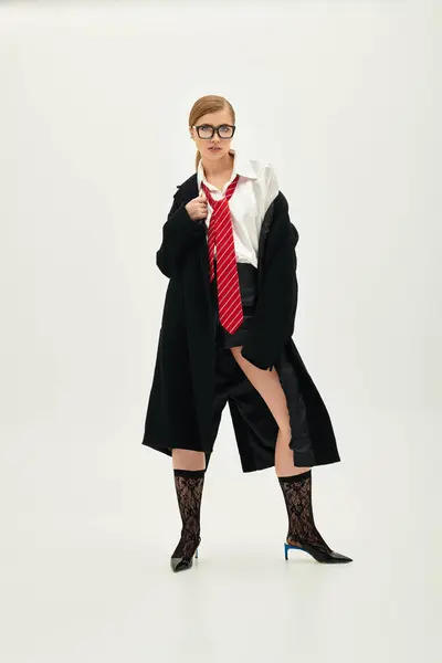 Молодая женщина демонстрирует свое чувство стиля с поразительным нарядом в гладкой студии. — стоковое фото