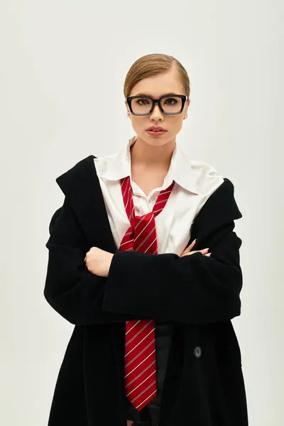 Uma jovem mulher exala confiança em uma roupa chique, contra um cenário de estúdio minimalista. — Fotografia de Stock