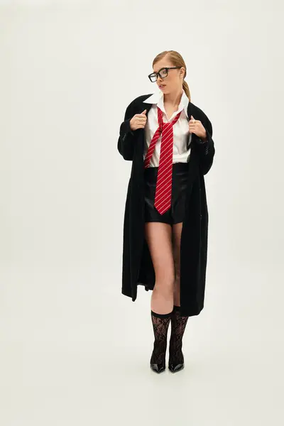 In a bright studio, a confident young woman showcases her fashionable outfit with flair and style. — Stock Photo