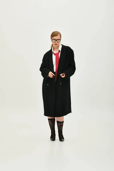 In a contemporary studio, a young woman displays a chic outfit and confident demeanor. — Stock Photo