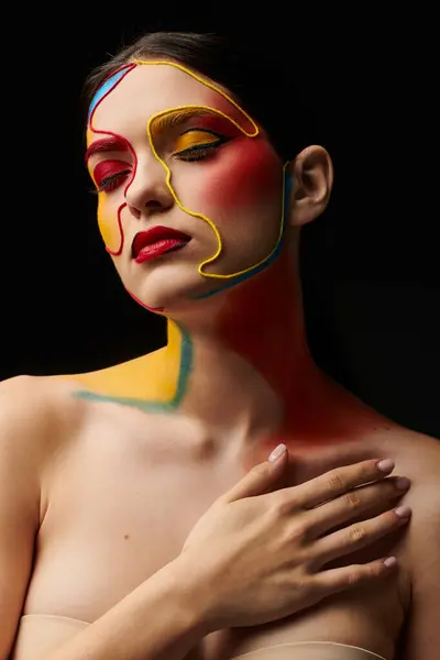 A stunning young woman displays vibrant face art with bold colors, embodying creativity and style. — Stock Photo