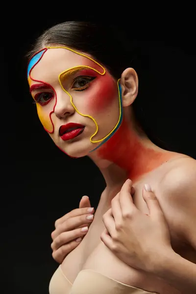 Young woman showcases colorful face art with creative designs, blending vibrant hues on her skin. — Stock Photo