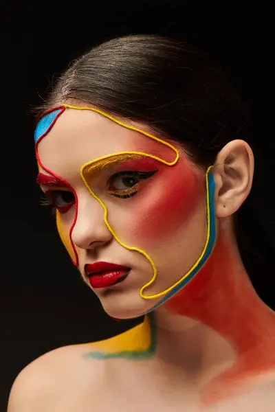 Una joven hermosa mujer muestra vibrante arte de la cara con colores audaces y diseños llamativos. - foto de stock