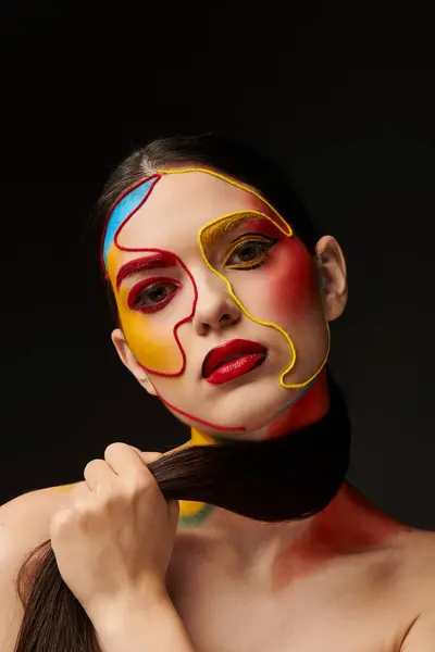 A young beautiful woman showcases vibrant face art, highlighting her bold makeup and style. — Stock Photo