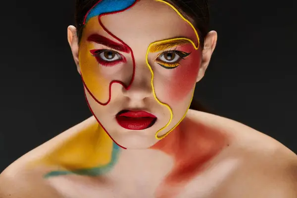 A young woman displays vibrant face art, blending colors that enhance her beauty and style. — Stock Photo