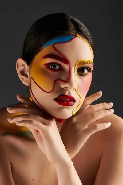A young woman showcases vibrant face art with bold colors, highlighting her beauty and style. — Stock Photo