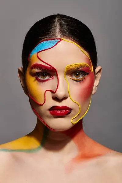 A young woman showcases vibrant face art, embodying creativity and colorful style. — Stock Photo
