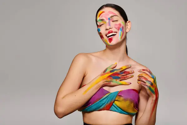 A cheerful young woman shows off her vibrant face makeup while smiling and posing. — Stock Photo