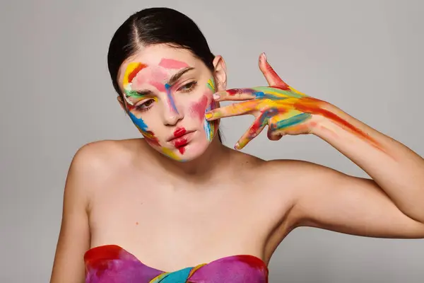A beautiful young woman displays vibrant face art, highlighting her artistic flair. — Stock Photo