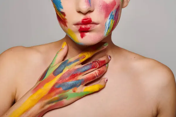 A young beautiful woman displays stunning face art with vibrant colors highlighting her features. — Stock Photo
