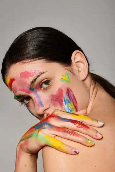 A young woman displays her vibrant face art, showcasing creativity and colorful style. — Stock Photo