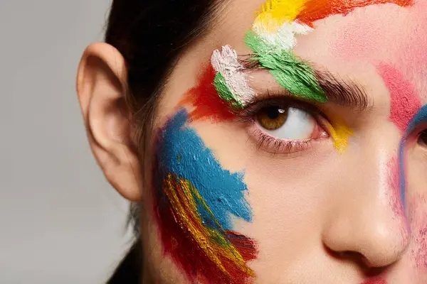 A young woman displays vibrant face art that enhances her beauty and style. — Stock Photo
