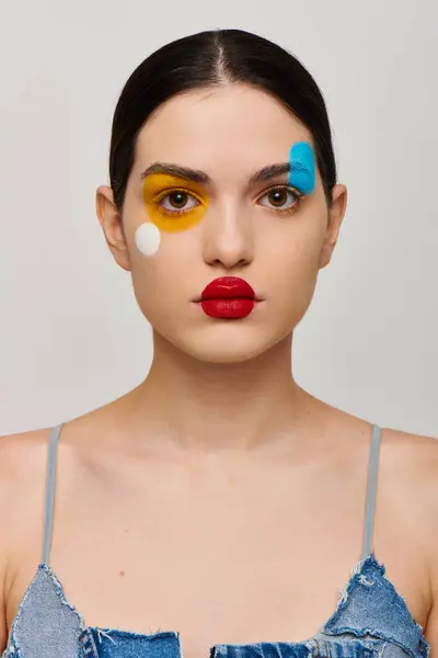 This young woman displays stunning face art that enhances her unique beauty with bold colors. — Stock Photo