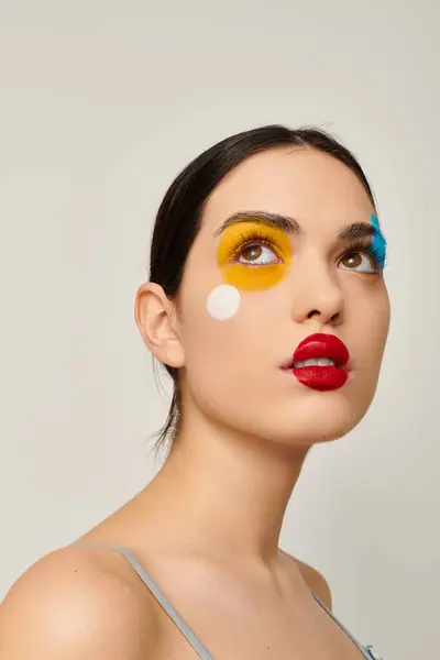 A young woman shows off vibrant face art that enhances her captivating beauty. — Stock Photo