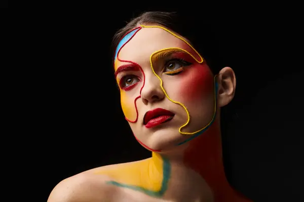 A young beautiful woman displays striking face art featuring vibrant colors and artistic patterns. — Stock Photo