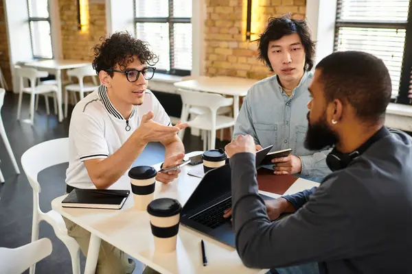 Three professionals exchange ideas in a bright workspace, focusing on teamwork and collaboration. — Stock Photo
