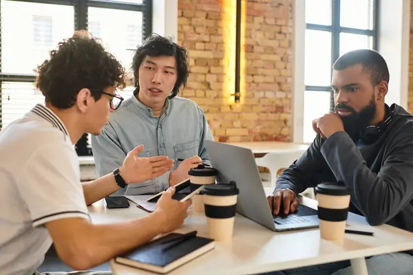 Três pessoas discutem produtivamente em um espaço de trabalho elegante sobre o café. — Fotografia de Stock