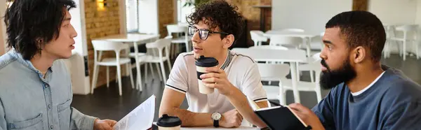 Tres individuos conversan y colaboran sobre bebidas en un espacio de trabajo elegante, compartiendo ideas. - foto de stock