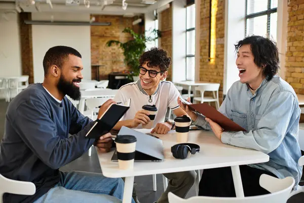 Drei Kollegen diskutieren lebhaft beim Kaffee in einem stilvollen Arbeitsbereich. — Stockfoto
