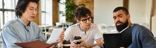 Trois personnes partagent idées et café dans un espace de travail moderne. — Photo de stock