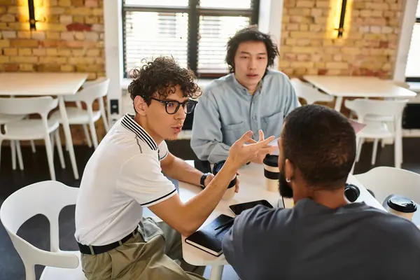 Three people discuss animatedly, sharing ideas in a bright, modern office. — Stock Photo