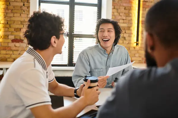 Three colleagues share ideas enthusiastically in a bright, inviting workspace. — Stock Photo