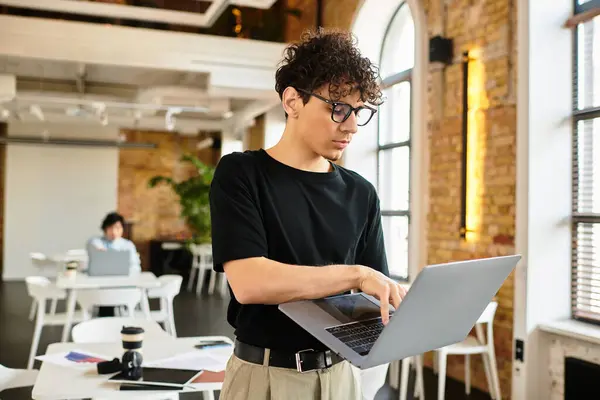 Bright office features a focused individual on a laptop, surrounded by modern decor. — Stock Photo