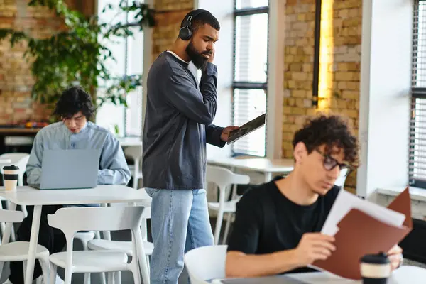 A diverse group is working in a bright, inviting co working space with plenty of greenery. — Stock Photo