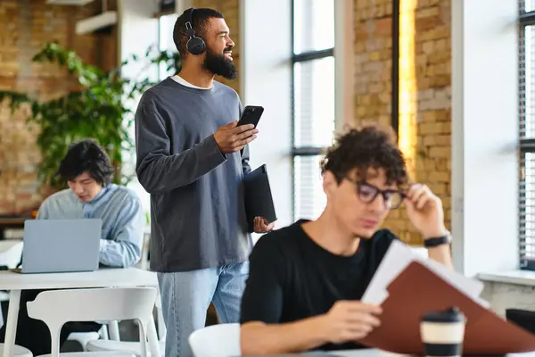 Young professionals use technology in a bright, green, and airy office space. — Stock Photo