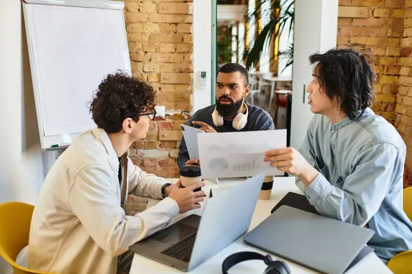Three professionals collaborate on a project in a stylish office filled with natural light. — Stock Photo