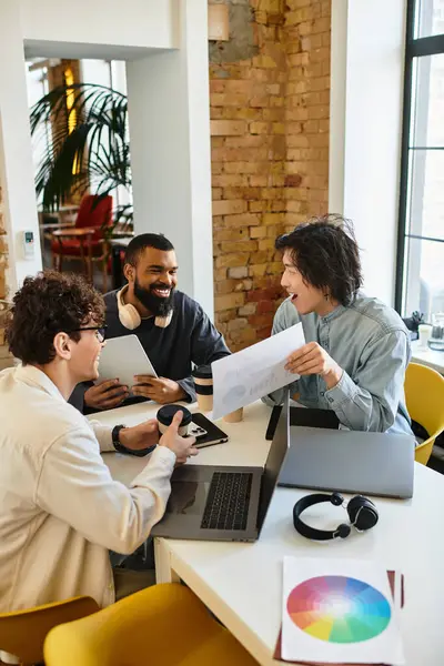 Three colleagues collaborate over documents in a creative, modern workspace. — Stock Photo